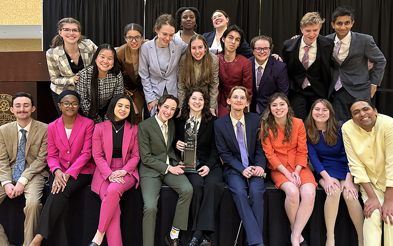 A group of 20 students face the camera and smile.