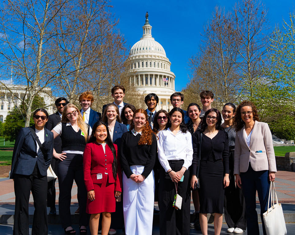 Group of students stand in front of the Capitol building.
