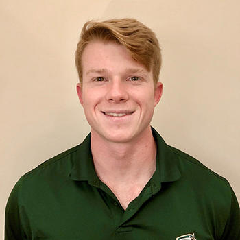 Schar School student Lewis Grant in a green George Mason University shirt.